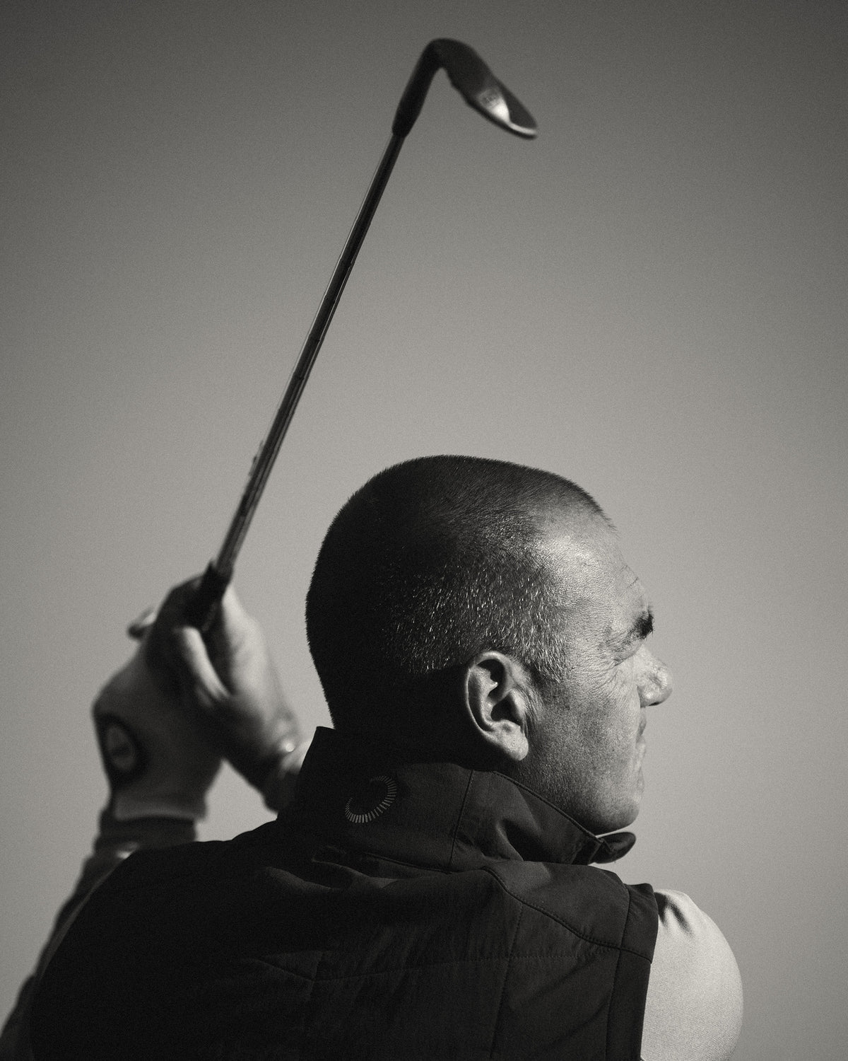 Golfer following through on a swing, low light