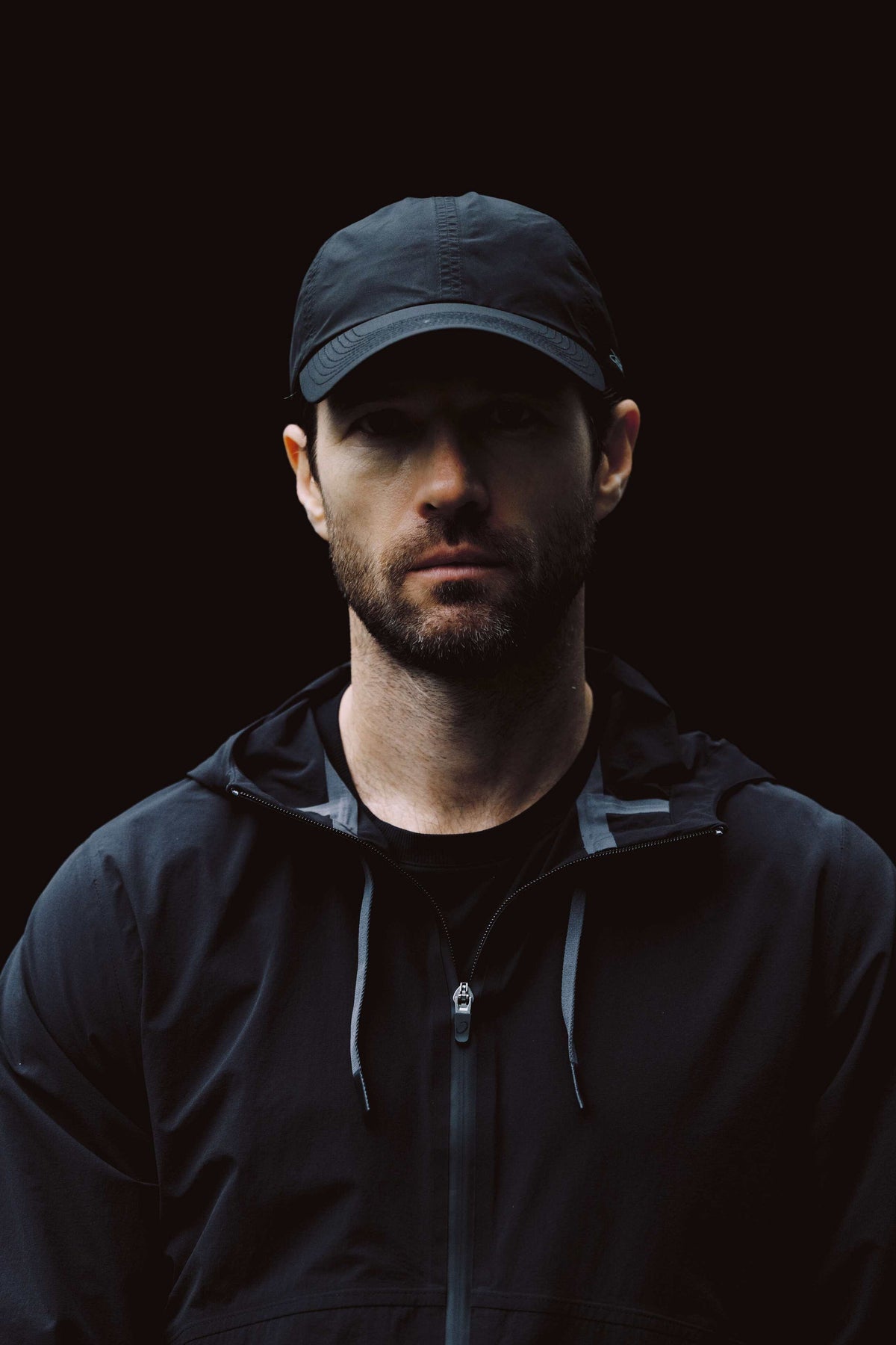 Man in a dark hooded jacket, moody portrait